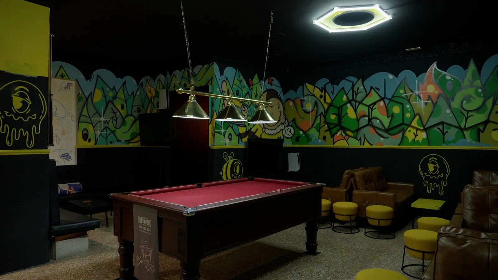 Sala de billar con murales de graffiti y luz cálida