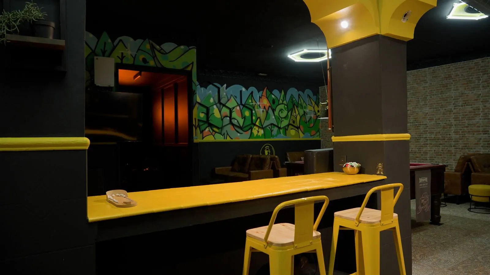 Barra interior de Brosin con iluminación cálida y mural